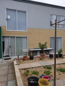 ein Gebäude mit Fenstern und Topfpflanzen davor in der Unterkunft DIANELLA Budget Rooms Happy Place to Stay & House Share For Long Term Tenants in Perth