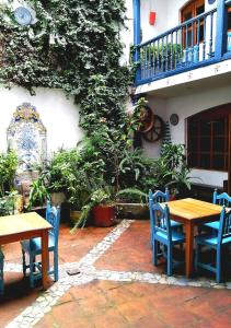 a patio with tables and chairs and a balcony at Doña Esther Otavalo in Otavalo