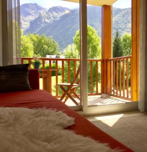 卢登维耶尔Appartement-Terrasse "Les Edelweiss" - Loudenvielle location的一间带床的卧室和一个可欣赏美景的阳台