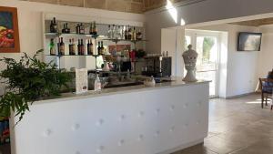 - un bar avec un comptoir avec des bouteilles de vin dans l'établissement Giardini di Marzo, à Felline