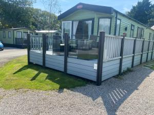 a mobile home with a fence around it at lake view staycations in Carnforth
