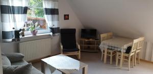 una pequeña sala de estar con mesa y TV en Ferienwohnung Strudthoff, en Ganderkesee