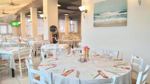 jadalnia z białymi stołami i białymi krzesłami w obiekcie HOTELRISTORANTE IL PUNTO w mieście Marotta