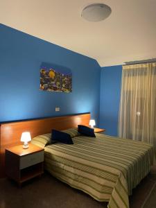 ヴァラッツェにあるHotel Inesの青い壁のベッドルーム1室(大型ベッド1台付)