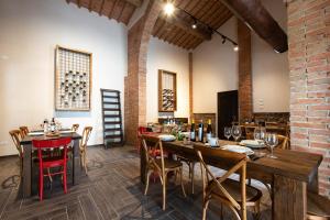 a dining room with tables and chairs and a brick wall at Monna Caterina Wine Resort in Vinci