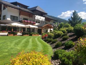 a hotel with a lawn in front of a building at Hotel Arnaria in Ortisei