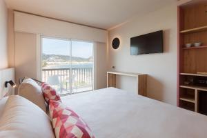 a bedroom with a bed and a large window at Hotel Maritim in Roses