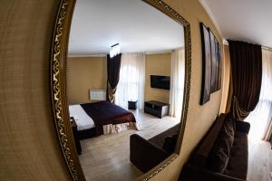 a hotel room with a bed and a mirror at Vinograd Hotel in Sochi