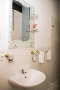 Baño blanco con lavabo y espejo en Hotel Boulevard, en Puerto Maldonado