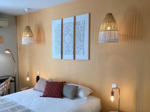 a bedroom with a bed and three pictures on the wall at A La Voile Blanche in Bouzigues