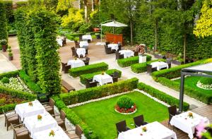 ein Restaurant mit weißen Tischen und Stühlen im Garten in der Unterkunft The Grand Mark Prague - The Leading Hotels of the World in Prag