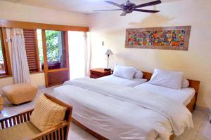 a bedroom with two beds and a ceiling fan at Nakula Familiar Inn in Denpasar