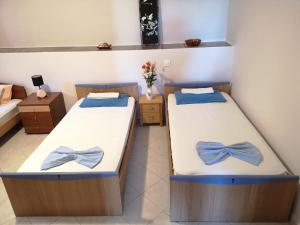 two beds with bow ties on them in a room at Panorama View Apartment 3 in Áyioi Apóstoloi