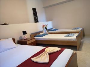 ein Hotelzimmer mit 2 Betten und Blumen darauf in der Unterkunft Panorama View Apartment 3 in Áyioi Apóstoloi