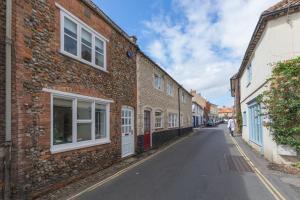 an empty street in a town with brick buildings at Lion Cottage in Holt