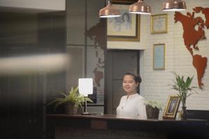 una mujer parada detrás de un mostrador en una oficina en New Star, en Pattaya central