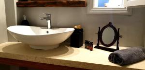 a bathroom with a sink and a mirror on a counter at Villa Εν Πλω (Enplo) in Grikos