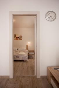 Cette chambre comprend un lit et une horloge murale. dans l'établissement Apartmani Dragica, à Rovinj