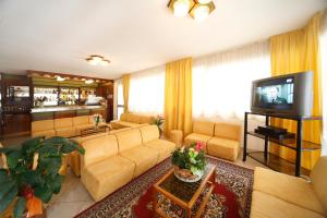 salon z kanapą i telewizorem w obiekcie Hotel Devon Rooms & Breakfast w Cesenatico