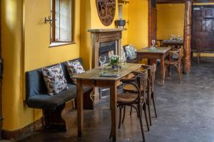 a dining room with tables and chairs and a fireplace at Rising Sun Pub, Restaurant and Rooms in Lacock