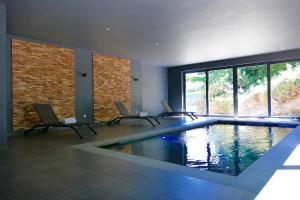 una habitación con una piscina con sillas. en Villa de Noailles, en Spa