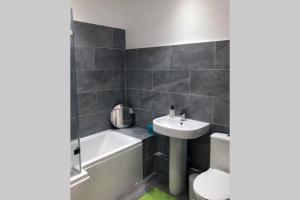 a bathroom with a sink and a tub and a toilet at Albion Cottage in Cockermouth +14 photos