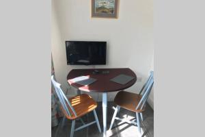 a dining room table with two chairs and a television at Albion Cottage in Cockermouth