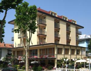 ein Gebäude mit Tischen und Stühlen davor in der Unterkunft Hotel Devon Rooms & Breakfast in Cesenatico