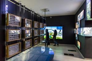 a woman walking through a room with a display of wine bottles at Apartmani More Komarna in Komarna