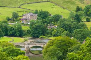 
a river that has a bridge over it at The Devonshire Fell Hotel in Burnsall
