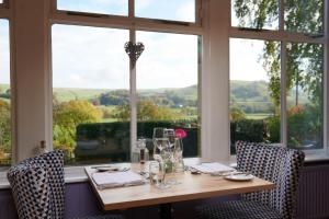 a table in a room with a large window at The Devonshire Fell Hotel in Burnsall