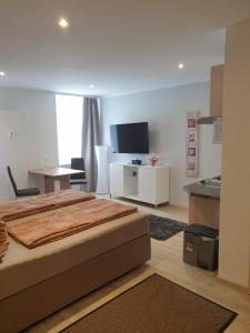 1 Schlafzimmer mit einem großen Bett und einer Küche in der Unterkunft Hausner`s Hotel-Apartments in Altenstadt an der Waldnaab
