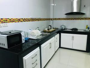 a kitchen with a microwave and a sink at Impact MT House in Ban Bang Phang