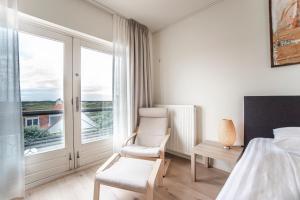 1 dormitorio con 1 cama, 2 sillas y ventana en Keller Beach, en Zandvoort