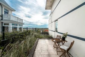un patio con 2 sillas y una mesa en el lateral de un edificio en Keller Beach, en Zandvoort
