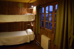 a bedroom with a bed and a window at Periko´s Youth Hostel in San Carlos de Bariloche