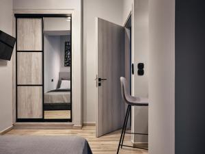 a bedroom with a door with a mirror and a bed at Pothos Suites in Zakynthos Town