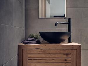 a bathroom with a sink on top of a wooden dresser at Pothos Suites in Zakynthos Town