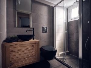 a bathroom with a sink and a toilet and a shower at Pothos Suites in Zakynthos Town