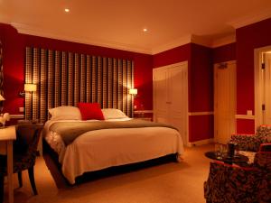 
a bedroom with a large bed and a large window at The Devonshire Fell Hotel in Burnsall
