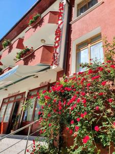 a building with red flowers in front of it at Yagodina Family Hotel in Yagodina
