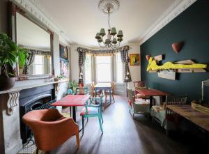 Cavalaire Guest House في برايتون أند هوف: غرفة معيشة مع طاولة وكراسي ومدفأة
