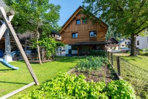 a garden in front of a wooden house at Apartmaji MM in Bohinj