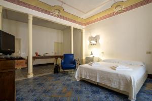 een slaapkamer met een bed, een bureau en een blauwe stoel bij Casa Particular Luxury in Palermo