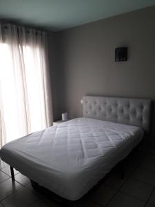 - un lit blanc dans une chambre avec 2 fenêtres dans l'établissement Appartement village Le Liberty 3 Argelès Sur Mer 2km plage, à Argelès-sur-Mer