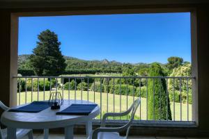 d'une table et de chaises sur un balcon avec vue. dans l'établissement Les Résidences de Métifiot, à Saint-Rémy-de-Provence