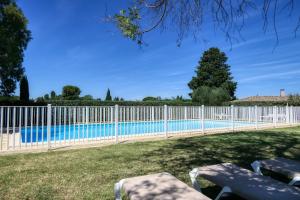 une clôture blanche autour d'une piscine dans l'établissement Les Résidences de Métifiot, à Saint-Rémy-de-Provence