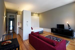 een woonkamer met een rode bank en een bed bij Trendy Flats Fontainhas in Porto