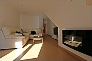 a living room with a couch and a tv at CASA VIRIATO in Ayamonte