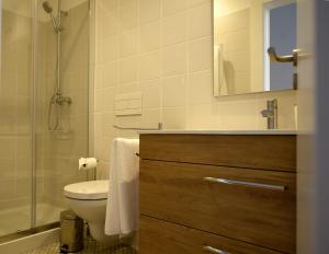 een badkamer met toilet en glazen douche bij Trendy Flats Fontainhas in Porto +78 foto's